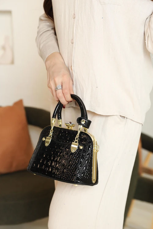 شنطة نسائية لون أسود بنقوش جلد التمساح مزينة باللون الذهبي