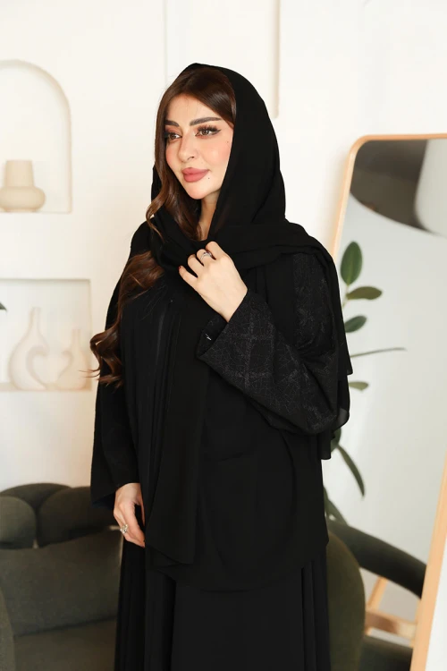 عباية نسائية لون أسود ياقة قصة سبعة بأزرار طقطق من الأمام و بأكمام بتطريزات هندسية مع طرحة