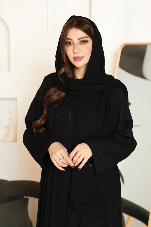 عباية نسائية لون أسود ياقة قصة سبعة بأزرار طقطق من الأمام و بأكمام بتطريزات هندسية مع طرحة
