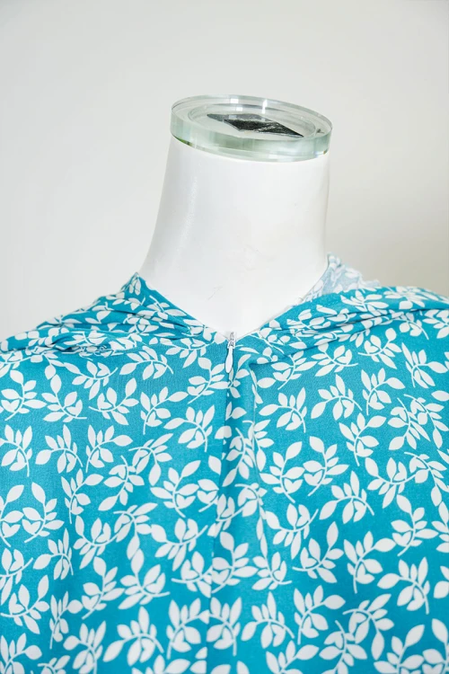 شرشف صلاة لون سماوي مشجر باللون الأبيض بسحاب مخفي من الأمام و زم من الأكمام مع طرحة متصلة