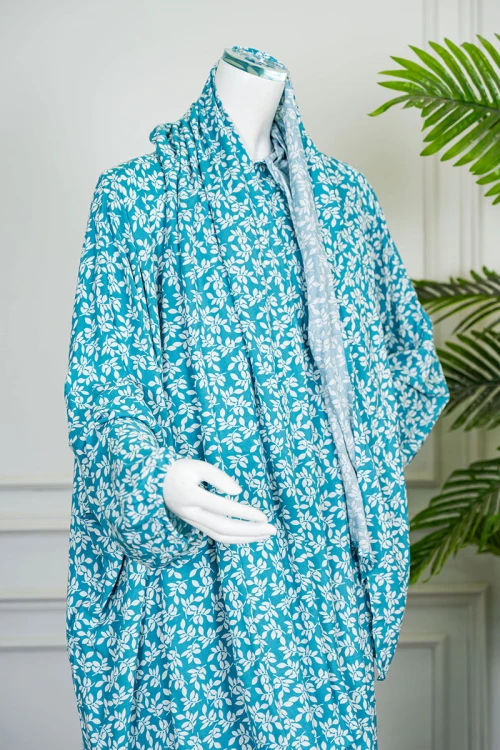 شرشف صلاة لون سماوي مشجر باللون الأبيض بسحاب مخفي من الأمام و زم من الأكمام مع طرحة متصلة