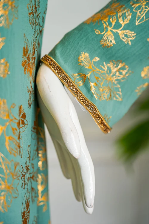 جلابية نسائية لون تفاحي مشجرة باللون الذهبي ياقة بقصة سبعة مزينة بكلفة مطرزة من الياقة و أطراف الأكمام