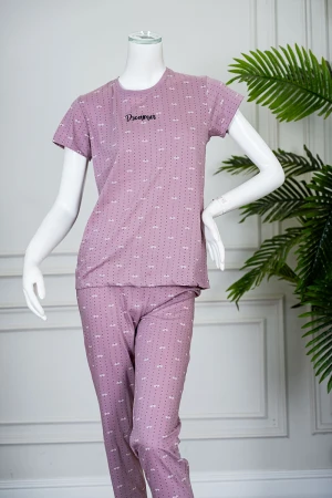 بيجاما نسائية قطعتين لون وردي منقطة باللون الأسود بلوزة بياقة دائرية مزينة بكتابات من الأمام و بأكمام قصيرة مع بنطلون طويل 