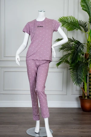 بيجاما نسائية قطعتين لون وردي منقطة باللون الأسود بلوزة بياقة دائرية مزينة بكتابات من الأمام و بأكمام قصيرة مع بنطلون طويل 