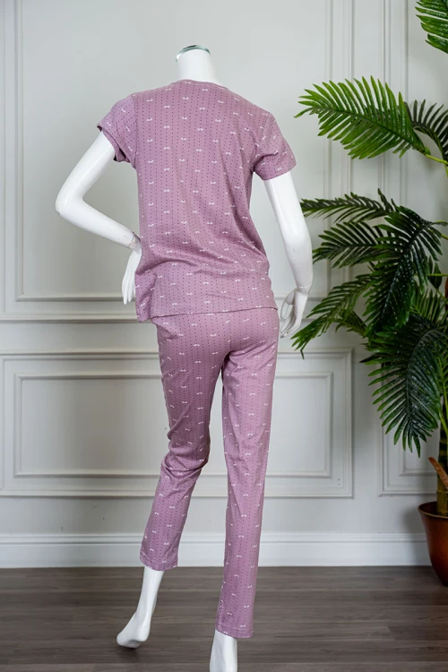 بيجاما نسائية قطعتين لون وردي منقطة باللون الأسود بلوزة بياقة دائرية مزينة بكتابات من الأمام و بأكمام قصيرة مع بنطلون طويل