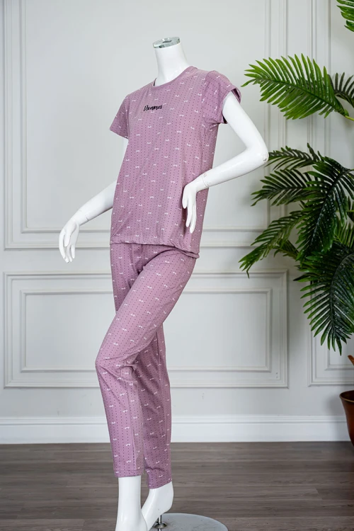 بيجاما نسائية قطعتين لون وردي منقطة باللون الأسود بلوزة بياقة دائرية مزينة بكتابات من الأمام و بأكمام قصيرة مع بنطلون طويل