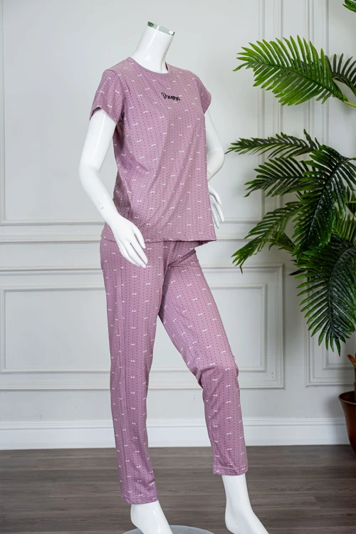 بيجاما نسائية قطعتين لون وردي منقطة باللون الأسود بلوزة بياقة دائرية مزينة بكتابات من الأمام و بأكمام قصيرة مع بنطلون طويل
