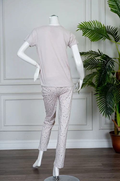 بيجاما نسائية قطعتين لون بيج فاتح بلوزة بياقة دائرية مزينة بكتابات من الأمام و بأكمام قصيرة مع بنطلون طويل مشجر