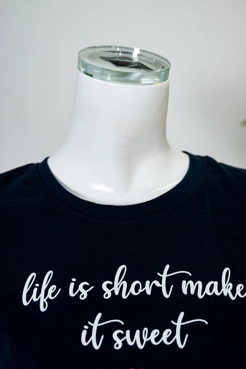 بيجاما نسائية قطعتين بلوزة لون كحلي بياقة دائرية مزينة بكتابات من الأمام و بأكمام قصيرة مع بنطلون اوف وايت طويل مزين بالقلوب