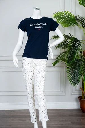 بيجاما نسائية قطعتين بلوزة لون كحلي بياقة دائرية مزينة بكتابات من الأمام و بأكمام قصيرة مع بنطلون اوف وايت طويل مزين بالقلوب 