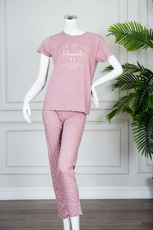 بيجاما نسائية قطعتين لون وردي بلوزة بياقة دائرية مزينة بكتابات من الأمام و بأكمام قصيرة مع بنطلون طويل مشجر