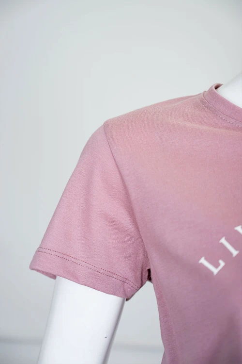 بيجاما نسائية قطعتين لون وردي بلوزة بياقة دائرية مزينة بكتابات من الأمام و بأكمام قصيرة مع بنطلون طويل مشجر