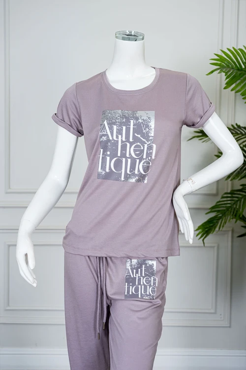 بيجاما نسائية قطعتين لون بنفسجي فاتح مزينة بكتابات من الأمام بلوزة بياقة دائرية و بأكمام قصيرة مع بنطلون طويل برباط في الخصر