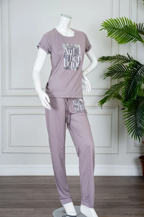 بيجاما نسائية قطعتين لون بنفسجي فاتح مزينة بكتابات من الأمام بلوزة بياقة دائرية و بأكمام قصيرة مع بنطلون طويل برباط في الخصر