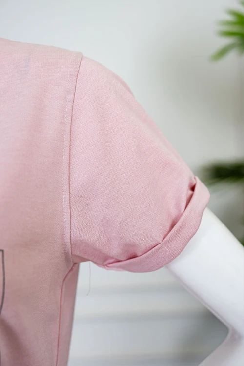 بيجاما نسائية قطعتين لون وردي بلوزة بياقة دائرية مزينة برسومات و كتابات من الأمام بأكمام قصيرة مع بنطلون طويل برباط في الخصر