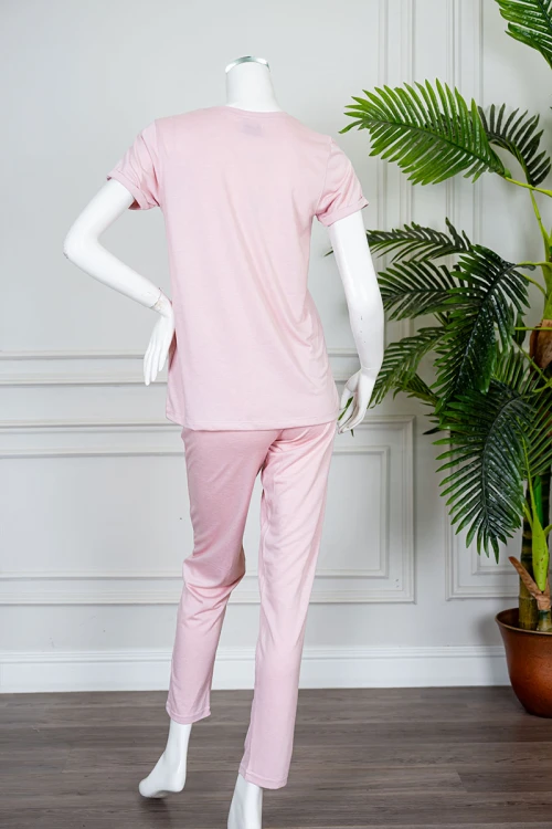 بيجاما نسائية قطعتين لون وردي بلوزة بياقة دائرية مزينة برسومات و كتابات من الأمام بأكمام قصيرة مع بنطلون طويل برباط في الخصر