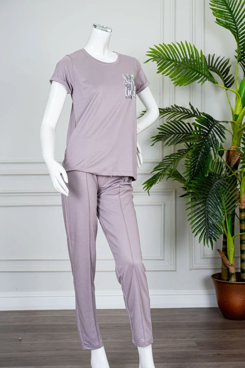 بيجاما نسائية قطعتين لون بنفسجي فاتح بلوزة بياقة دائرية مزينة برسومات و كتابات من الأمام بأكمام قصيرة مع بنطلون طويل برباط في الخصر