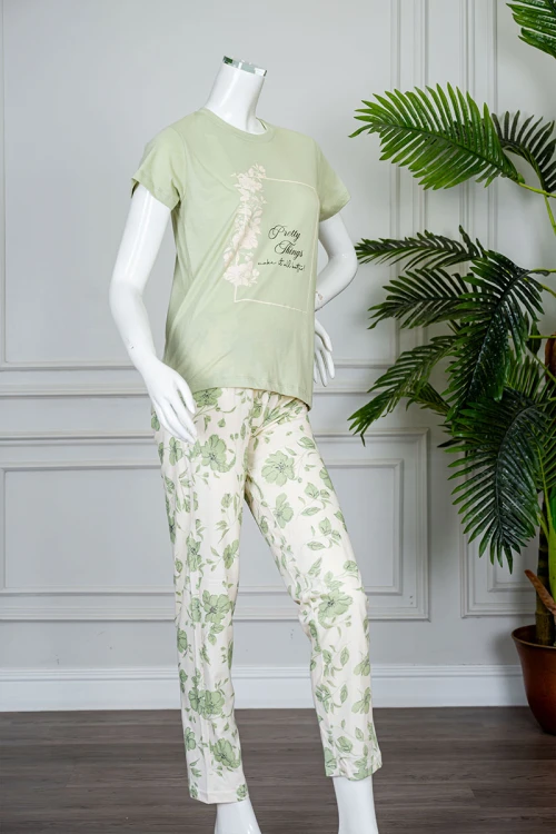 بيجاما نسائية قطعتين لون تفاحي بلوزة بياقة دائرية مزينة برسومات و كتابات من الأمام بأكمام قصيرة مع بنطلون طويل مشجر برباط في الخصر