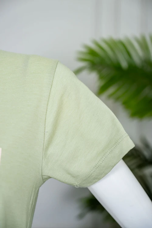 بيجاما نسائية قطعتين لون تفاحي بلوزة بياقة دائرية مزينة برسومات و كتابات من الأمام بأكمام قصيرة مع بنطلون طويل مشجر برباط في الخصر