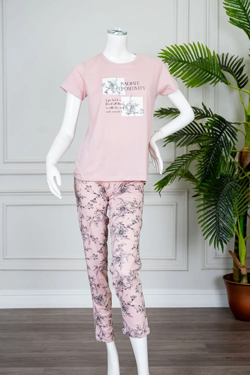 بيجاما نسائية قطعتين لون وردي بلوزة بياقة دائرية مزينة برسومات و كتابات من الأمام بأكمام قصيرة مع بنطلون طويل مشجر