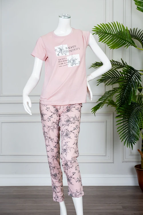 بيجاما نسائية قطعتين لون وردي بلوزة بياقة دائرية مزينة برسومات و كتابات من الأمام بأكمام قصيرة مع بنطلون طويل مشجر