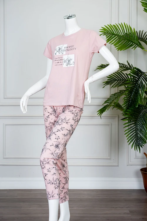 بيجاما نسائية قطعتين لون وردي بلوزة بياقة دائرية مزينة برسومات و كتابات من الأمام بأكمام قصيرة مع بنطلون طويل مشجر