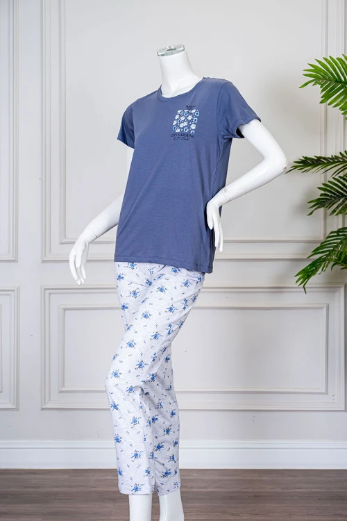 بيجاما نسائية قطعتين لون أزرق بلوزة بياقة دائرية مزينة برسومات و كتابات من الأمام بأكمام قصيرة مع بنطلون لون أبيض مشجر