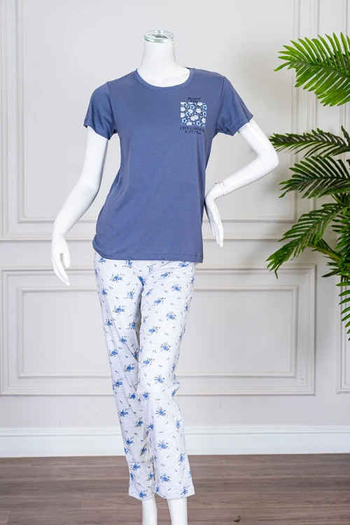 بيجاما نسائية قطعتين لون أزرق بلوزة بياقة دائرية مزينة برسومات و كتابات من الأمام بأكمام قصيرة مع بنطلون لون أبيض مشجر