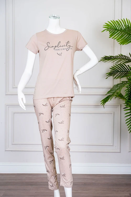 بيجاما نسائية قطعتين لون بيج بلوزة بياقة دائرية مزينة برسومات و كتابات من الأمام بأكمام قصيرة مع بنطلون مشجر