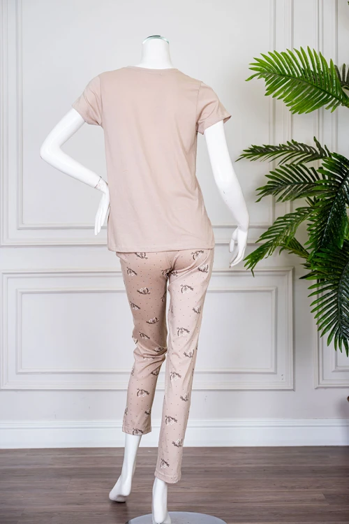 بيجاما نسائية قطعتين لون بيج بلوزة بياقة دائرية مزينة برسومات و كتابات من الأمام بأكمام قصيرة مع بنطلون مشجر