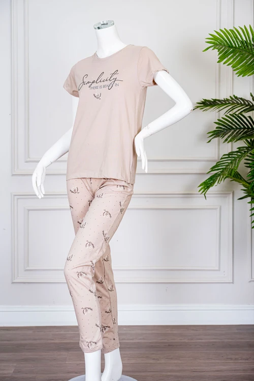 بيجاما نسائية قطعتين لون بيج بلوزة بياقة دائرية مزينة برسومات و كتابات من الأمام بأكمام قصيرة مع بنطلون مشجر