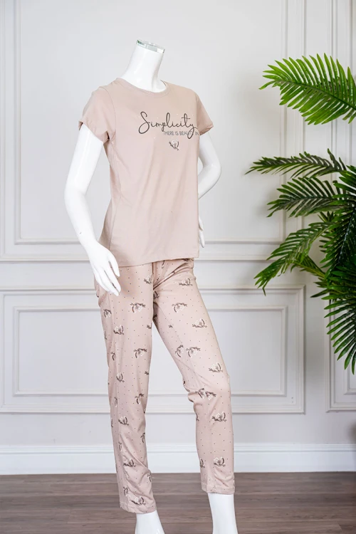 بيجاما نسائية قطعتين لون بيج بلوزة بياقة دائرية مزينة برسومات و كتابات من الأمام بأكمام قصيرة مع بنطلون مشجر
