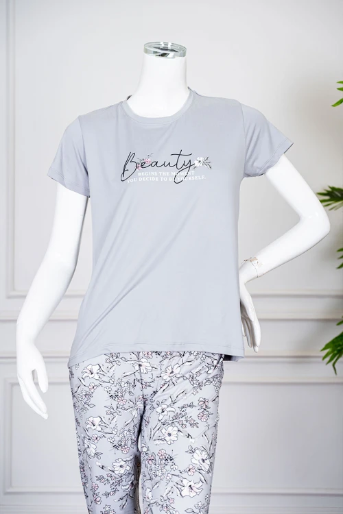 بيجاما نسائية قطعتين لون رمادي بلوزة بياقة دائرية مزينة برسومات و كتابات من الأمام بأكمام قصيرة مع بنطلون مشجر