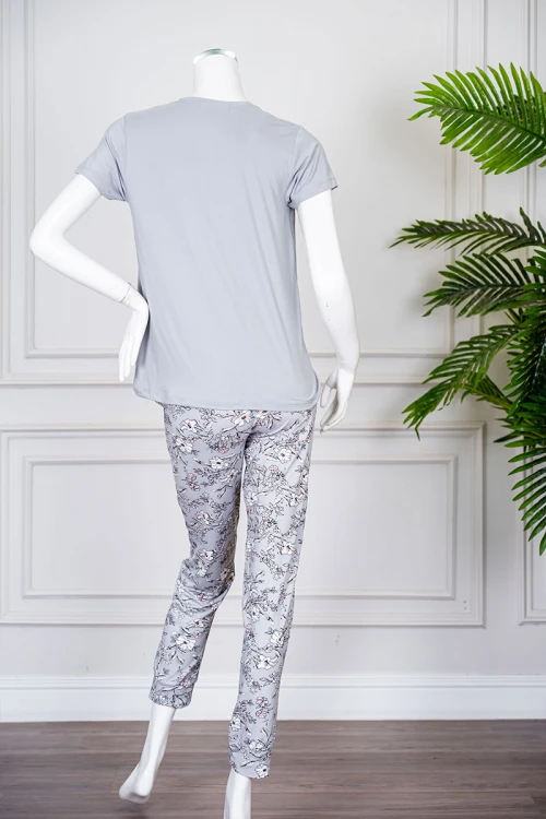 بيجاما نسائية قطعتين لون رمادي بلوزة بياقة دائرية مزينة برسومات و كتابات من الأمام بأكمام قصيرة مع بنطلون مشجر