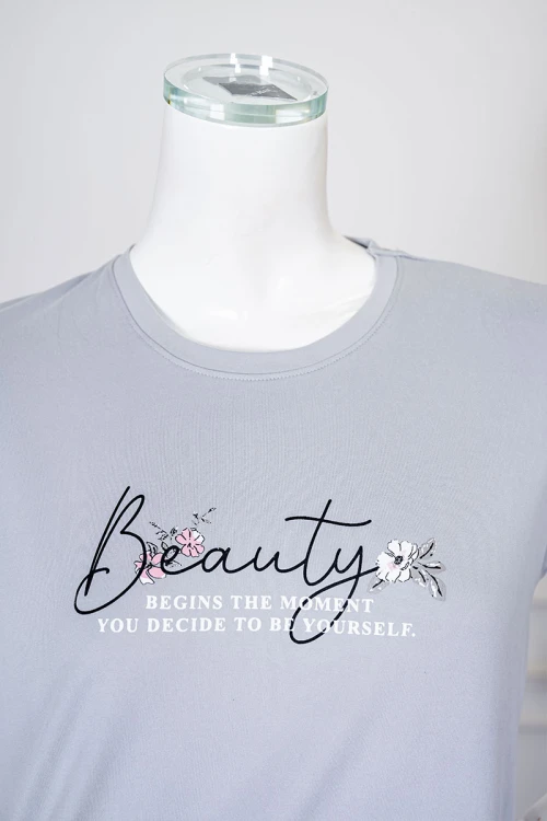 بيجاما نسائية قطعتين لون رمادي بلوزة بياقة دائرية مزينة برسومات و كتابات من الأمام بأكمام قصيرة مع بنطلون مشجر