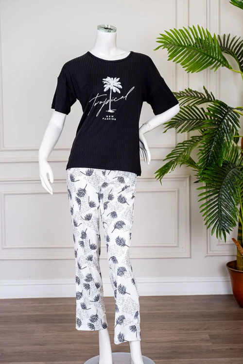 بيجاما نسائية قطعتين لون أسود بلوزة بياقة دائرية مزينة برسومات و كتابات من الأمام بأكمام قصيرة مع بنطلون أبيض مشجر