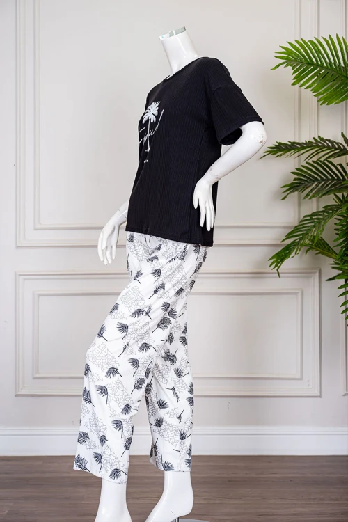 بيجاما نسائية قطعتين لون أسود بلوزة بياقة دائرية مزينة برسومات و كتابات من الأمام بأكمام قصيرة مع بنطلون أبيض مشجر