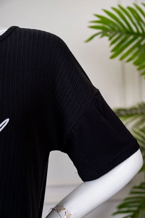 بيجاما نسائية قطعتين لون أسود بلوزة بياقة دائرية مزينة برسومات و كتابات من الأمام بأكمام قصيرة مع بنطلون أبيض مشجر