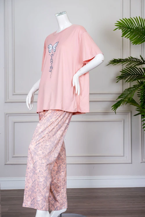 بيجاما نسائية قطعتين لون خربزي بلوزة بياقة دائرية مزينة برسومات و كتابات من الأمام بأكمام قصيرة مع بنطلون مشجر