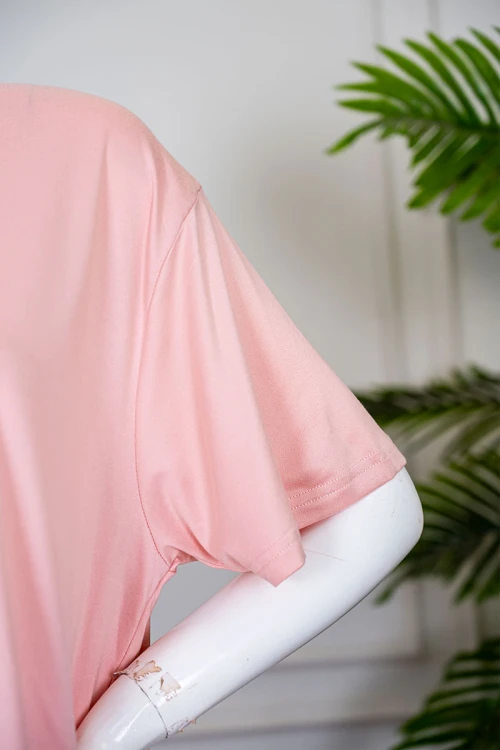 بيجاما نسائية قطعتين لون خربزي بلوزة بياقة دائرية مزينة برسومات و كتابات من الأمام بأكمام قصيرة مع بنطلون مشجر