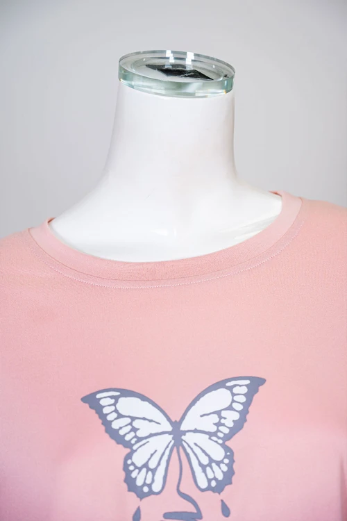 بيجاما نسائية قطعتين لون خربزي بلوزة بياقة دائرية مزينة برسومات و كتابات من الأمام بأكمام قصيرة مع بنطلون مشجر