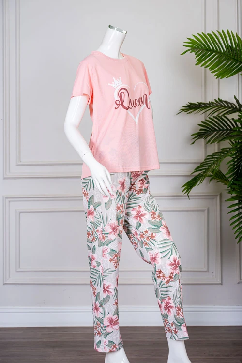 بيجاما نسائية قطعتين تيشيرت لون خربزي بياقة دائرية مزينة برسومات و كتابات من الأمام بأكمام قصيرة مع بنطلون طويل مشجر