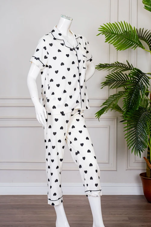 بيجاما نسائية قطعتين لون اوف وايت مزينة بقلوب باللون الأسود  بلوزة بياقة مطوية بجيب من الأمام و أكمام قصيرة مع بنطلون طويل