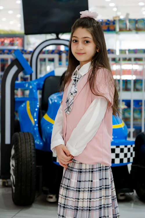 طقم بناتي من 3 قطع قميص أبيض بياقة مطوية و كرفته و أزرار من الأمام مع جاكيت باللون الوردي و تنورة كاروهات مع حزام أسود