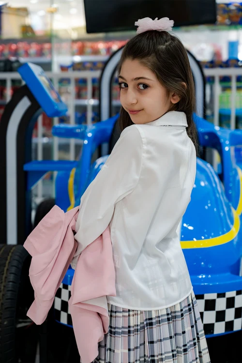 طقم بناتي من 3 قطع قميص أبيض بياقة مطوية و كرفته و أزرار من الأمام مع جاكيت باللون الوردي و تنورة كاروهات مع حزام أسود