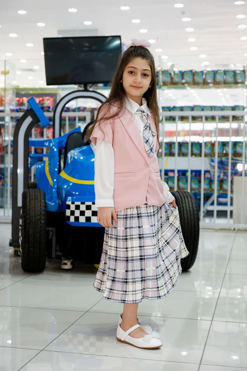 طقم بناتي من 3 قطع قميص أبيض بياقة مطوية و كرفته و أزرار من الأمام مع جاكيت باللون الوردي و تنورة كاروهات مع حزام أسود