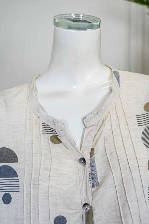 قميص نسائي طويل لون اوف وايت مزين بأشكال ملونة ياقة دائرية بأزرار من الأمام و بأكمام ميدي