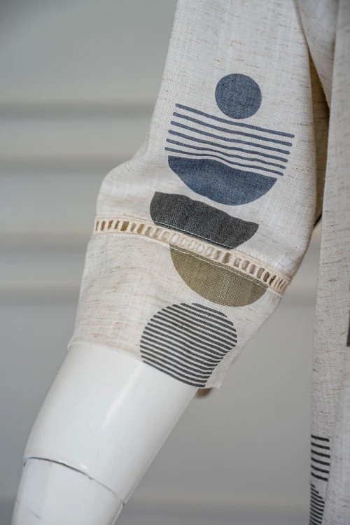 قميص نسائي طويل لون اوف وايت مزين بأشكال ملونة ياقة دائرية بأزرار من الأمام و بأكمام ميدي