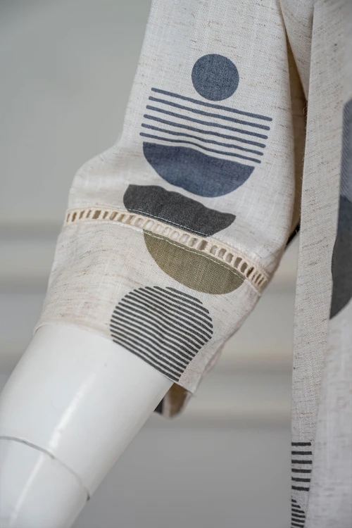 قميص نسائي طويل لون اوف وايت مزين بأشكال ملونة ياقة دائرية بأزرار من الأمام و بأكمام ميدي