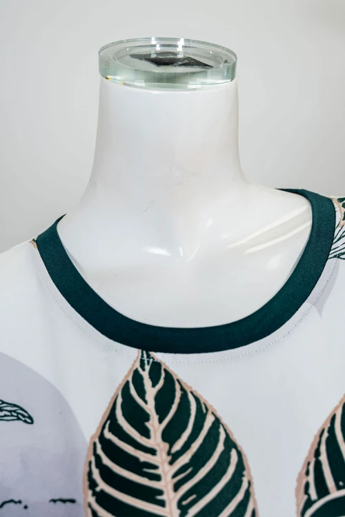 قميص نسائي طويل لون أبيض مشجر باللون الأخضر ياقة دائرية و بأكمام قصيرة